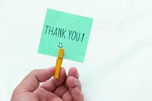 Thank you note in hand business context emotional connection simple setup close-up view gratitude in the workplace photo