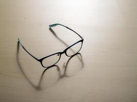 Stylish eyeglasses on wooden surface close-up view modern design minimalist aesthetic photo