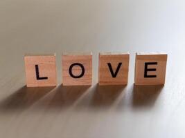 Minimalist space close-up of heartfelt love message with wooden blocks photo