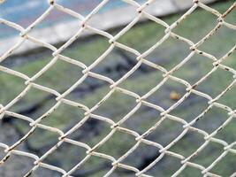Rusty white chain link fence urban environment close-up abstract view texture exploration photo