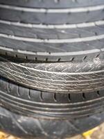 Automotive workshop close-up detailed inspection of stacked tires in industrial setting photo
