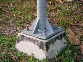 Metal pole structural base in industrial outdoor setting grass and ground level engineering photo