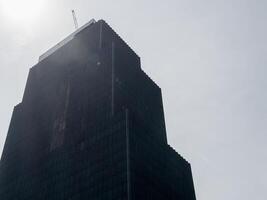 Skyscraper under mysterious fog urban city cloudy atmosphere low angle architectural design photo