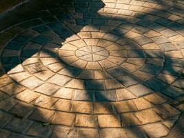 Circular pattern of shadows pavement outdoor space morning light ground level visual aesthetics photo