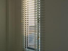 Urban morning sunlight streaming through blinds close-up view of serenity and brightness photo