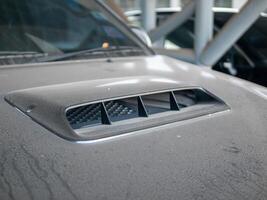 Performance concept car engine hood scoop in detailed automotive workshop setting photo