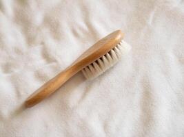 Handcrafted wooden brush soft fabric surface studio setting product close-up view natural concept photo