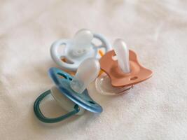 Baby pacifiers soft fabric newborn care essentials home setting close-up view parenting tips photo