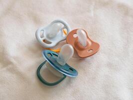 Baby pacifiers soft fabric nursery setting still life calm vibe close-up infant care photo