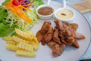 Delicious grilled chicken with salad and dipping sauces restaurant food bright setting close-up photo