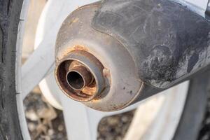 Close-up of a corroded motorcycle exhaust pipe in rusty condition in a mechanical environment photo