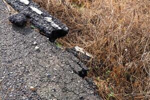 Road damage and erosion impacting infrastructure urban area dry environment ground level urban decay photo