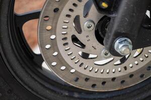 Close-up of motorcycle brake disc in technical garage workshop environment photo