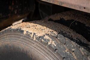 Ground level image of worn-out truck tire in dusty industrial environment - transport focus photo