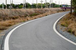 Curving pathway through open fields rural area natural environment perspective journey concept photo