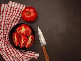 Fresh tomatoes in a black bowl on a table photo