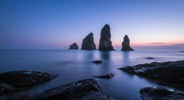 Serene ocean landscape featuring dramatic rock formations under a twilight sky creating a peaceful and scenic view photo