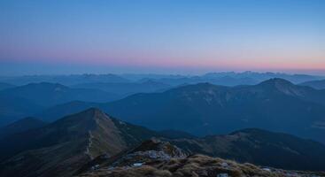 Layered mountain peaks stretch to the horizon during twilight offering a panoramic view of nature photo