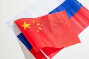 Fluttering juxtaposition of Chinese and Russian flags symbolizes diplomatic ballet, cultural symphony, and unconventional Unity Day reflections photo