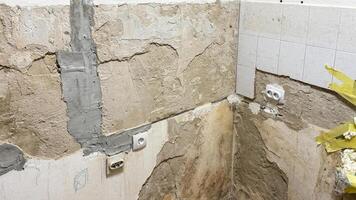 Cracked plaster wall in abandoned kitchen evokes rustic charm, ideal for Renewal Day or quirky Renovation Appreciation Week photo