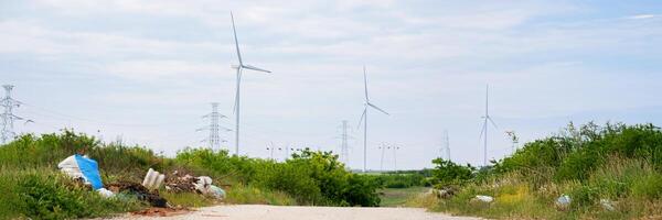 Wind turbines spin lazily above a discarded symphony of chaos, echoing Eco Conscious Day and Earth focused resolutions photo