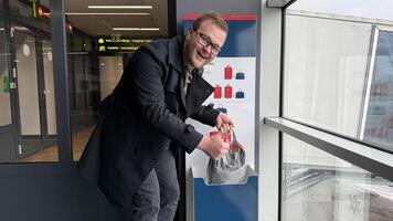 Smiling man of undetermined ethnicity enjoys quirkiest airport carousel shuffle, embodying Global Take a Walk in the Park Day photo