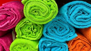 Vibrantly rolled rainbow towels stacked like candy, echoing Holis festive riot, igniting textile rejuvenation and chromatic mindfulness photo
