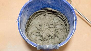 Whirling cement in a cobalt bucket spins tales of artisan craftsmanship, echoing Labor Day and World Creativity Day photo