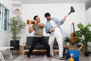 Couple Enjoying Fun Cleaning Moment at Home. Playful interaction while vacuuming. photo