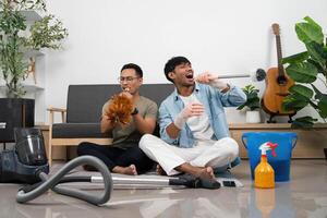 Fun Cleaning Session with Friends. Two young men enjoying music while cleaning their home. photo