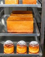 Golden sponge cakes symphonize with cinnamon rolls, invoking Yorkshire Pudding Day, bakers alchemy, and the scent of nostalgia photo