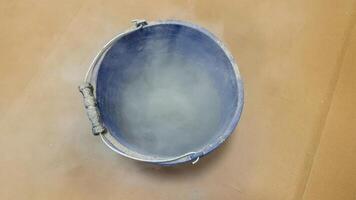 Misty vapor swirls in a vintage cerulean bucket evoke enigmatic alchemy and International Day of Blue Magic whimsy photo