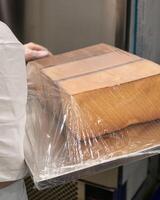 A stack of wooden rectangles, shrouded in glistening plastic wrap, evokes an artisans clandestine yule tide workshop magic photo