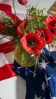 Bustling crimson poppies dance with tangled greenery against a backdrop of stars and stripes, reflecting Memorial Day introspection photo