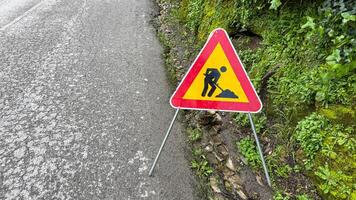 Roadside sign dances on mossy verge, whispering tales of hidden labor under Aprils Fool Day tricksters wink photo