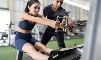 Fitness Trainer Assisting Client with Rowing Machine Workout photo