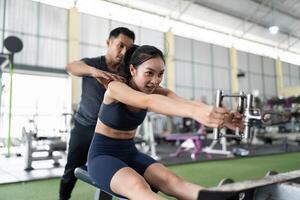 Personal Trainer Assisting Client with Rowing Machine Exercise photo
