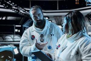 Astronauts doing brainstorming, conducting safety checks using tablet during long distance space travel. Starship colleagues talking, updating flight log during cosmic journey photo