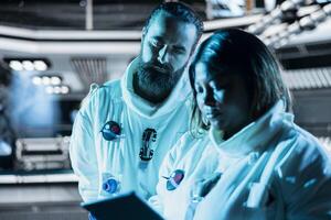 Teamworking cosmonauts exploring planetary surfaces, preparing for mission outside. Orbital station coworkers beginning landing procedures on blue planet, mapping unknown worlds photo