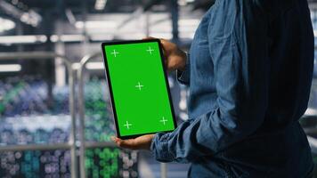 Data center worker using green screen mockup tablet, doing maintenance on rigs handling AI tasks. Server hub admin using chroma key device to manage storage arrays supporting deep learning photo
