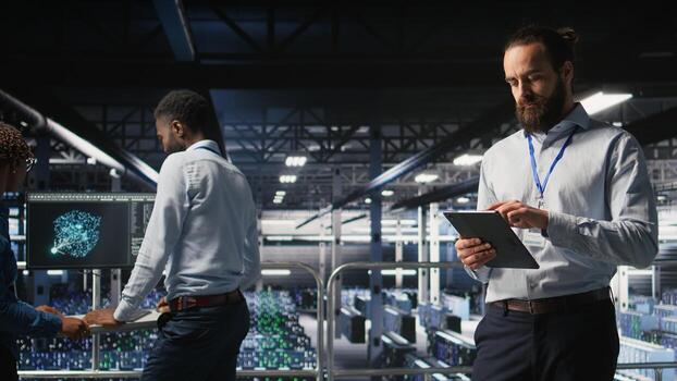 Server room technician next to coworkers reviewing neural network code and LLM visualization dashboards. Data center IT specialist next to colleagues monitoring AI system performance, photo