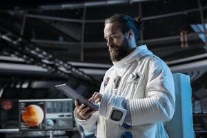 Cosmonaut in orbital station ensuring operational readiness before mission launch to Mars. Man working on spaceship doing Martian surface research to advance scientific knowledge photo