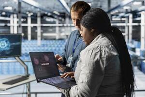 Server hub colleagues using AI to detect abnormal network traffic patterns caused by hacker attack. Data center specialists deploying artificial intelligence countermeasures to neutralize hacking photo