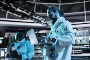 Astronaut tracking star and asteroids patterns on laptop to ensure safe operation during space travel. Orbital station crew member looking at galaxy visualization during cosmic journey photo