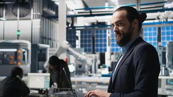 Solar panels industry technician in a high tech factory for inspection, quality control production metrics. Professional engineer ensuring industrial operations for efficiency. Camera A. photo