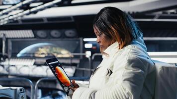 Astronaut using tablet to check analytics after completing red planet surface mission on unfamiliar planet. Cosmonaut leaving Mars, inputting navigation coordinates on device to return home photo