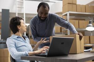 Diverse workers managing the order logistics for small business shipment operations, ensuring express delivery for a local brand. Working on product handling in the supply room. E commerce. photo