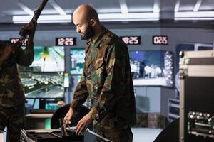 Operatives conducing anti terrorism mission, loading weapons, preparing to track enemy forces threatening national security. Army soldiers packing guns, preparing to start assault mission photo