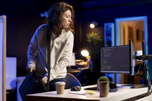 System administrator arriving in office, ready to design and develop software applications on laptop. IT expert starting job shift, unpacking notebook, implementing and maintaining company systems photo