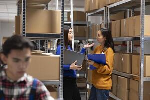 Asian staff members checking parcels at a startup fulfillment center. Local delivery and in house logistics supported by organized storage, taped boxes and efficient inventory management. photo